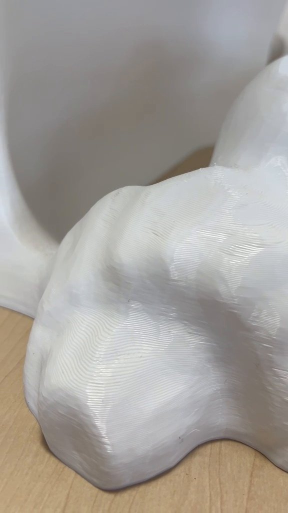 Close-up of a curved 3D-printed surface with visible layer lines